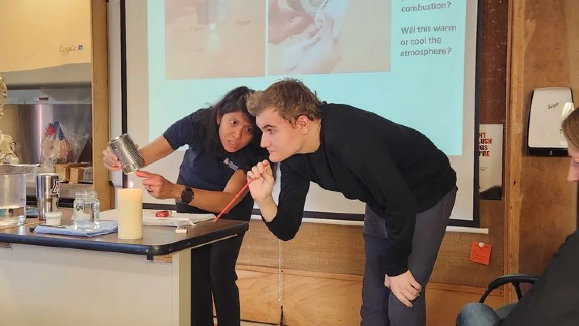 Genie Lorenzo (23-24 Carson Scholar) and Kino School student using a tin can and candle in a hands-on demonstration