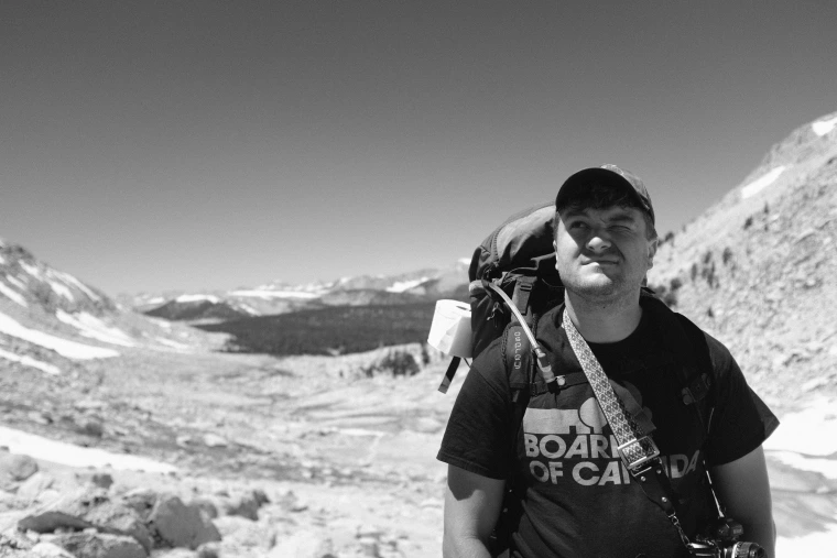 Black and white image of James Paules backpacking. 
