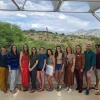 Photo of Carson Scholars 2023-2024 cohort. 13 graduate students standing in a line at Biosphere 2 with the Sonoran Desert in the background.